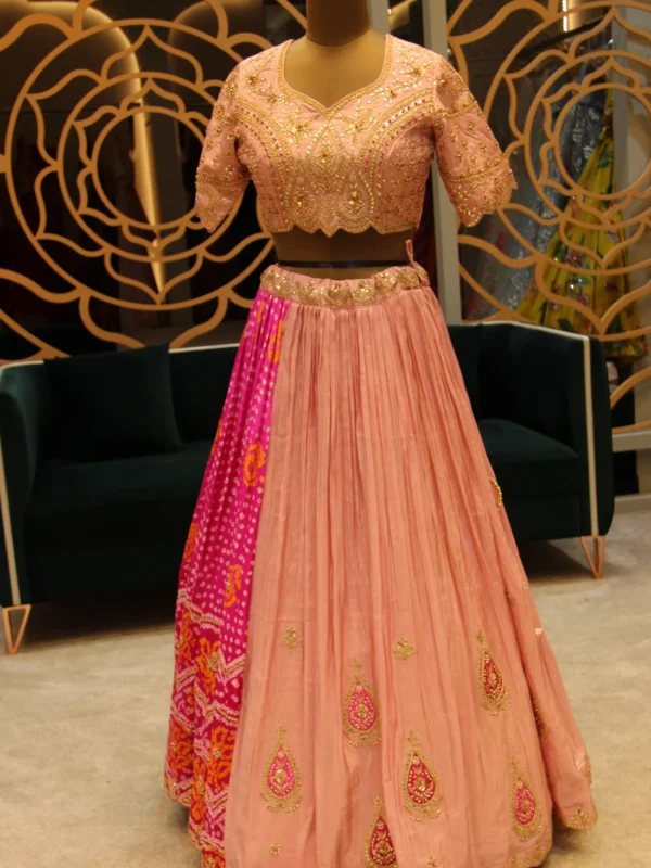 Pink satin silk designer lehenga embellished with Gota Patti embroidery and Bandhani patchwork on one side, paired with matching blouse and dupatta — ideal for sangeet and festive occasions.