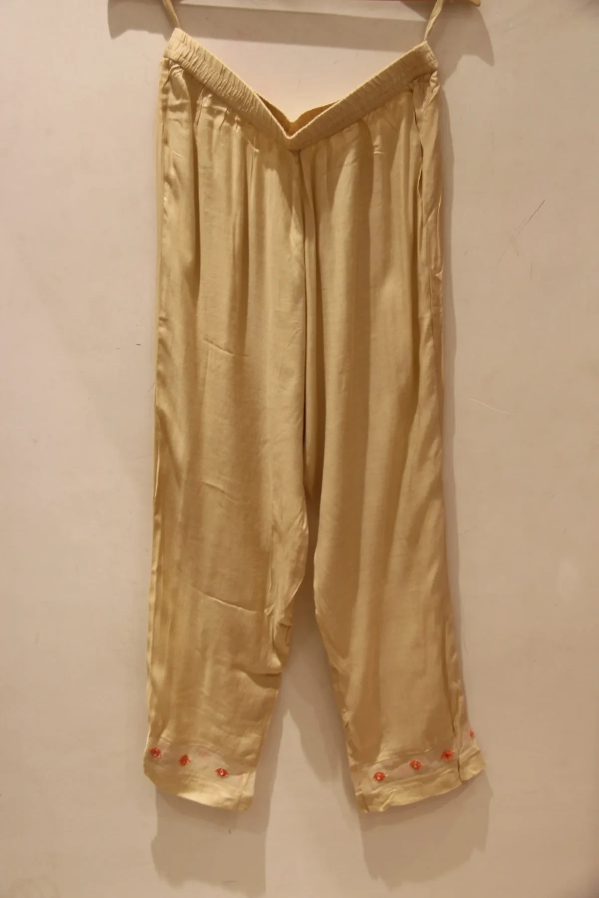 Peach muslin suit for women with floral print and highlight work, paired with matching pants and dupatta – elegant festive wear.