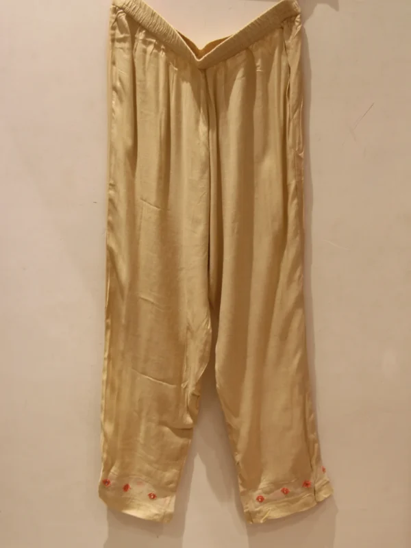 Peach muslin suit for women with floral print and highlight work, paired with matching pants and dupatta – elegant festive wear.