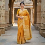 Elegant woman wearing mustard yellow Moonga Tussar saree with Pichwai-inspired print and woven zari border – Rangoli Saris