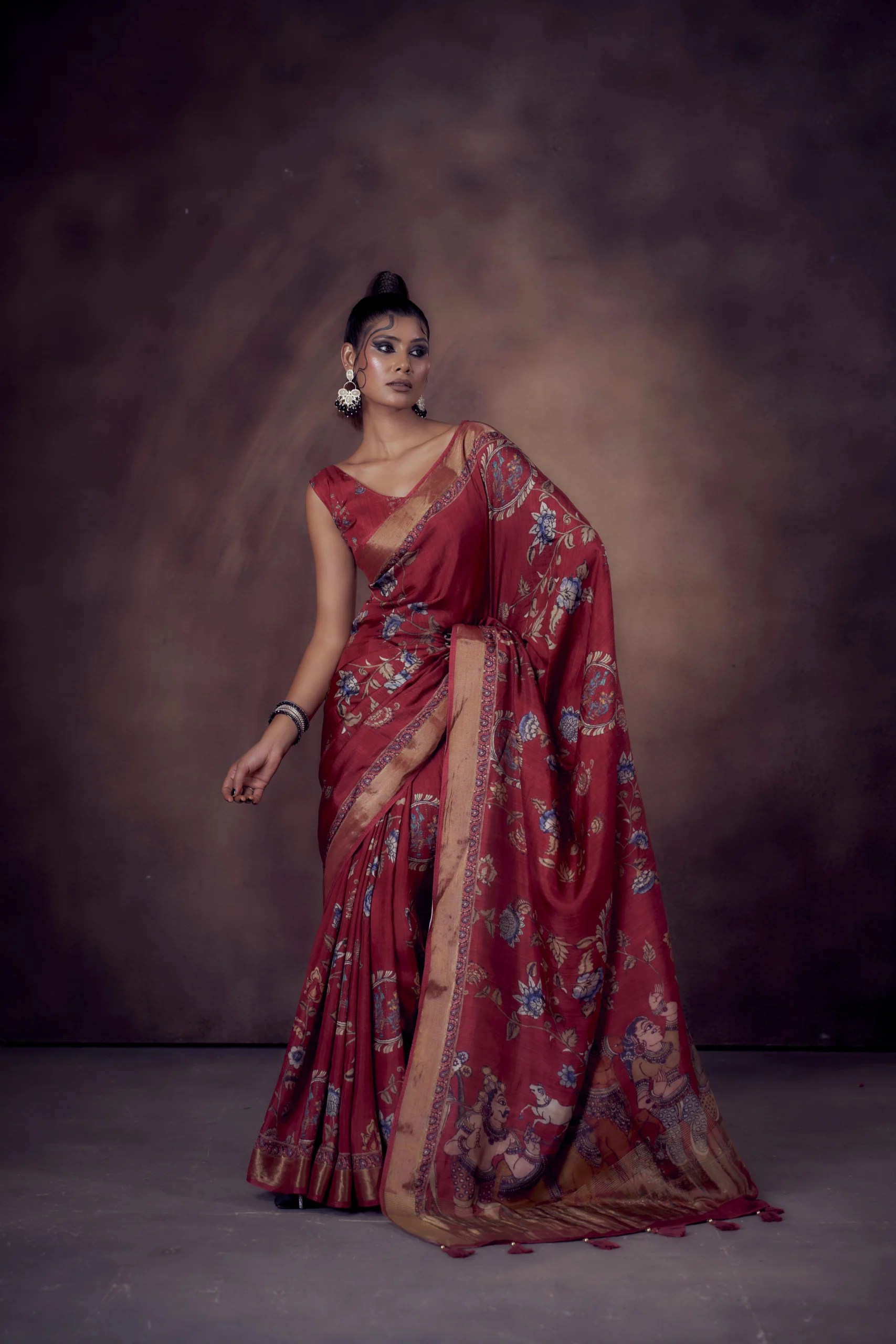 Ruby Moonga Tussar saree with Kalamkari and Pichwai prints featuring woven zari border