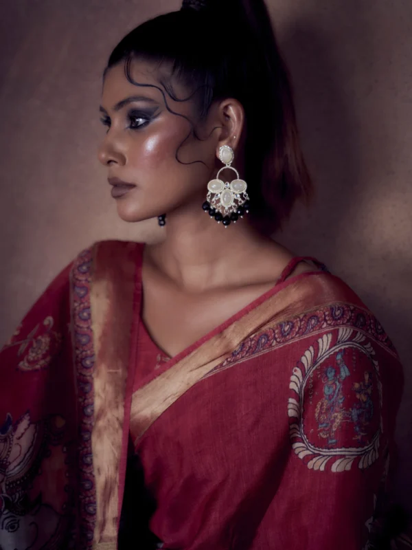 Ruby Moonga Tussar saree with Kalamkari and Pichwai prints featuring woven zari border