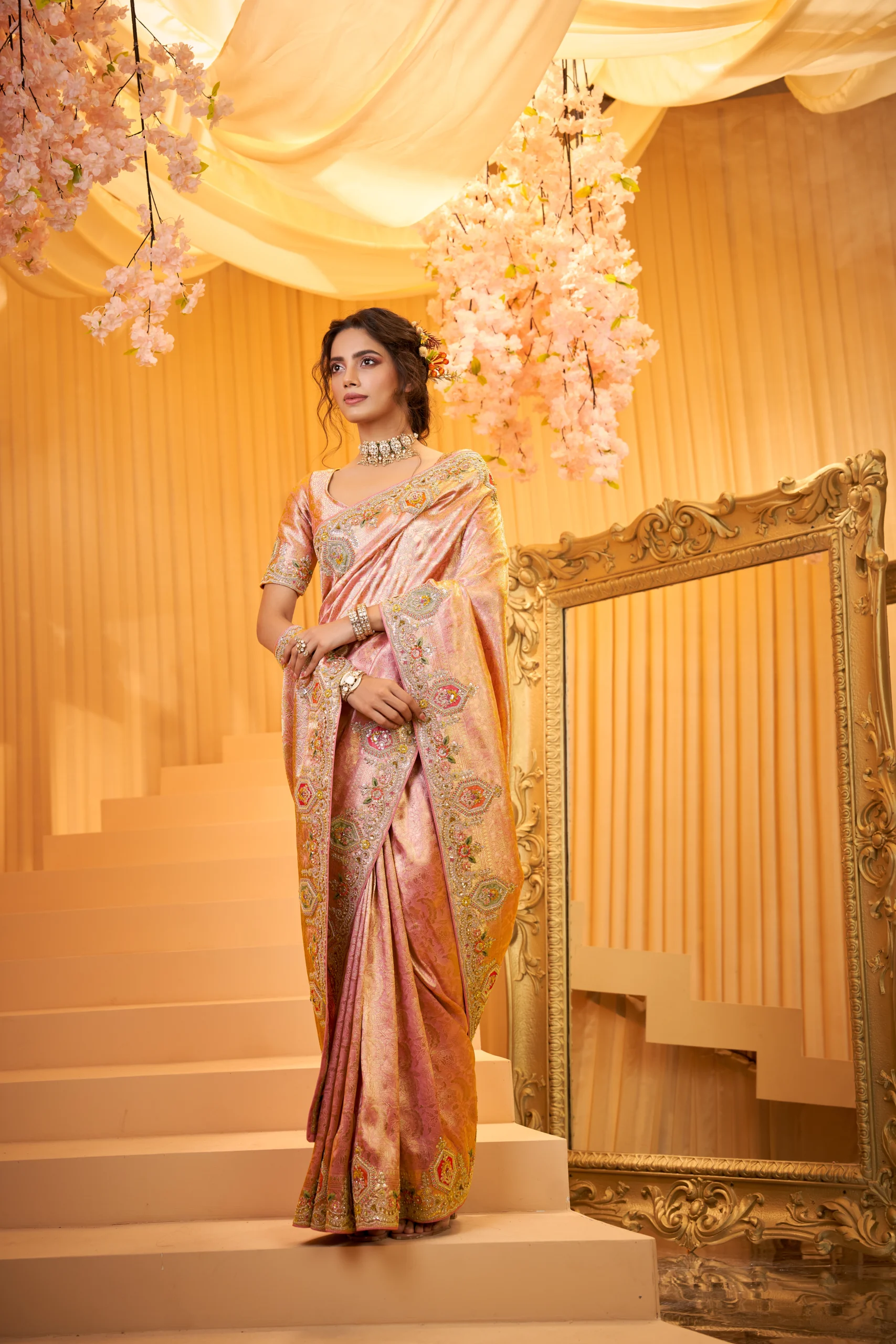 Model wearing rose gold designer handloom saree with intricate embroidery and unstitched blouse