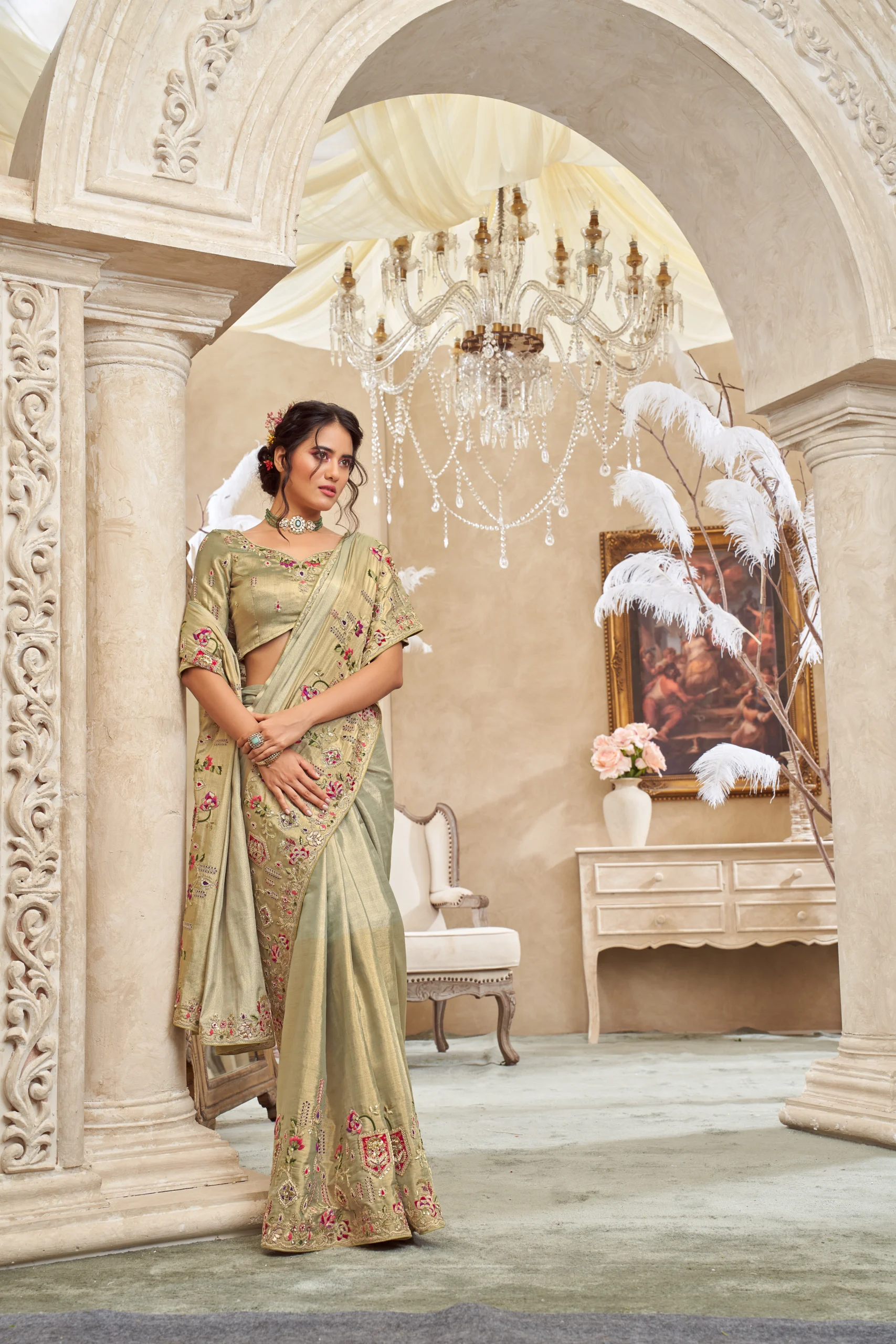 Model wearing an ivory olive designer saree with intricate hand embroidery and unstitched blouse.