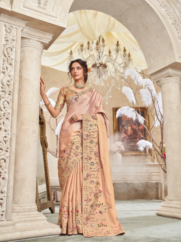 Model wearing a blush caramel hand-embroidered designer saree with ornate detailing and unstitched blouse.