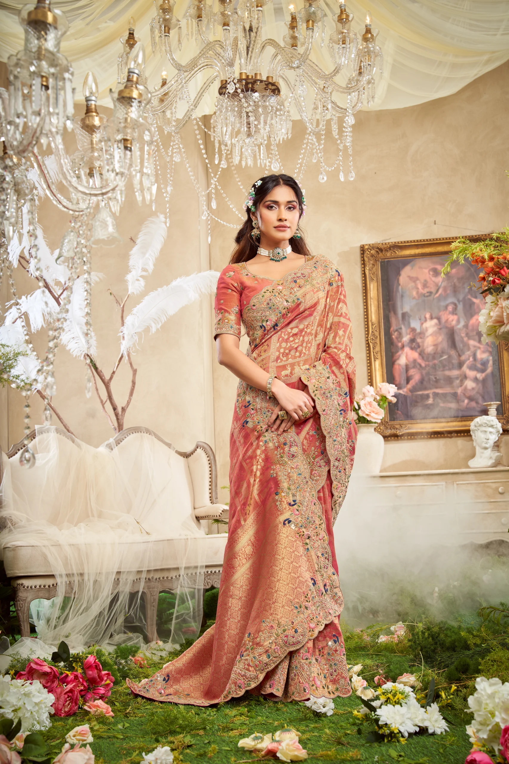 Model draped in a coral hand-embroidered luxury designer saree with heavy border and unstitched blouse.