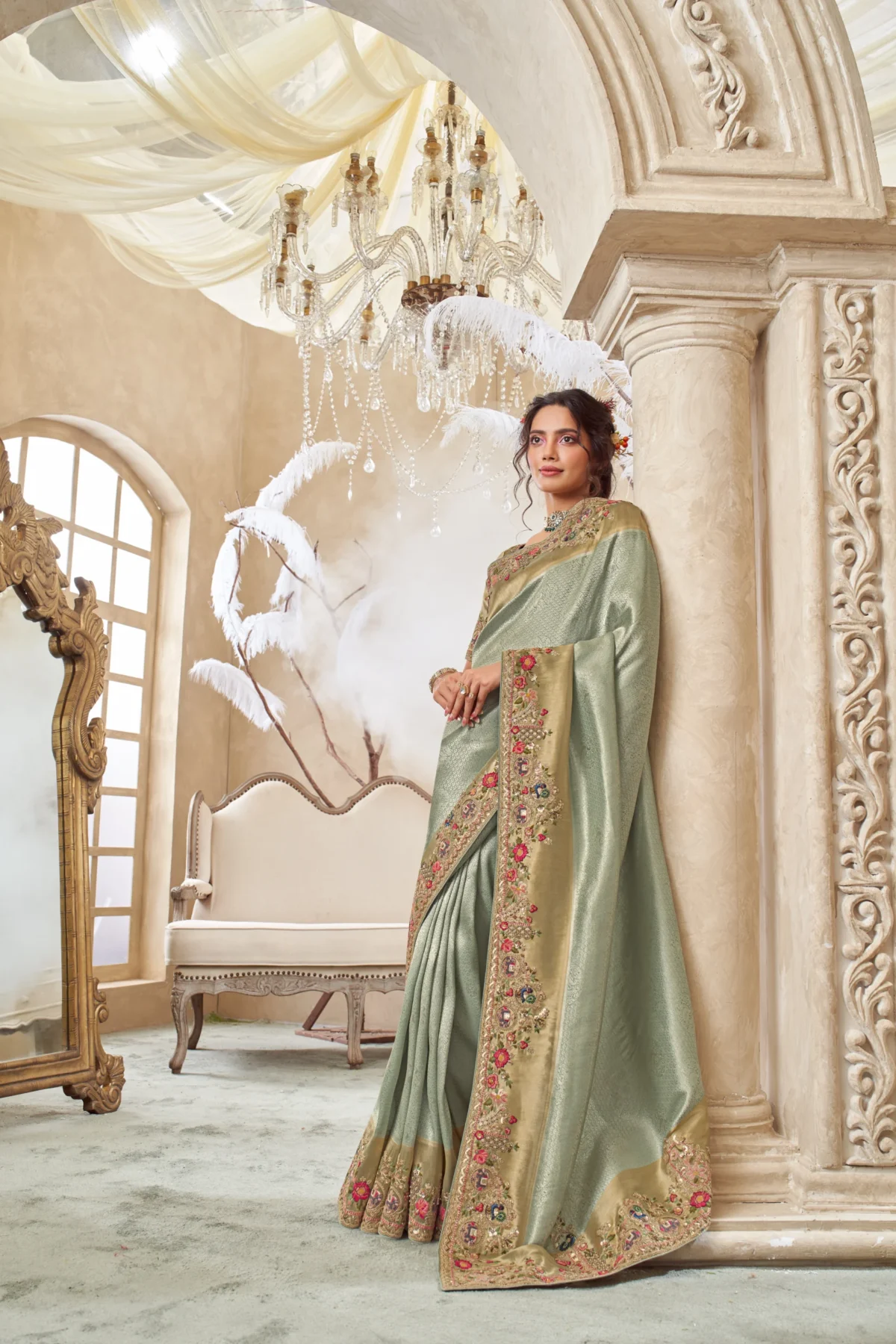 Model wearing a mint gold hand-embroidered designer saree with heavily embellished border and unstitched blouse.