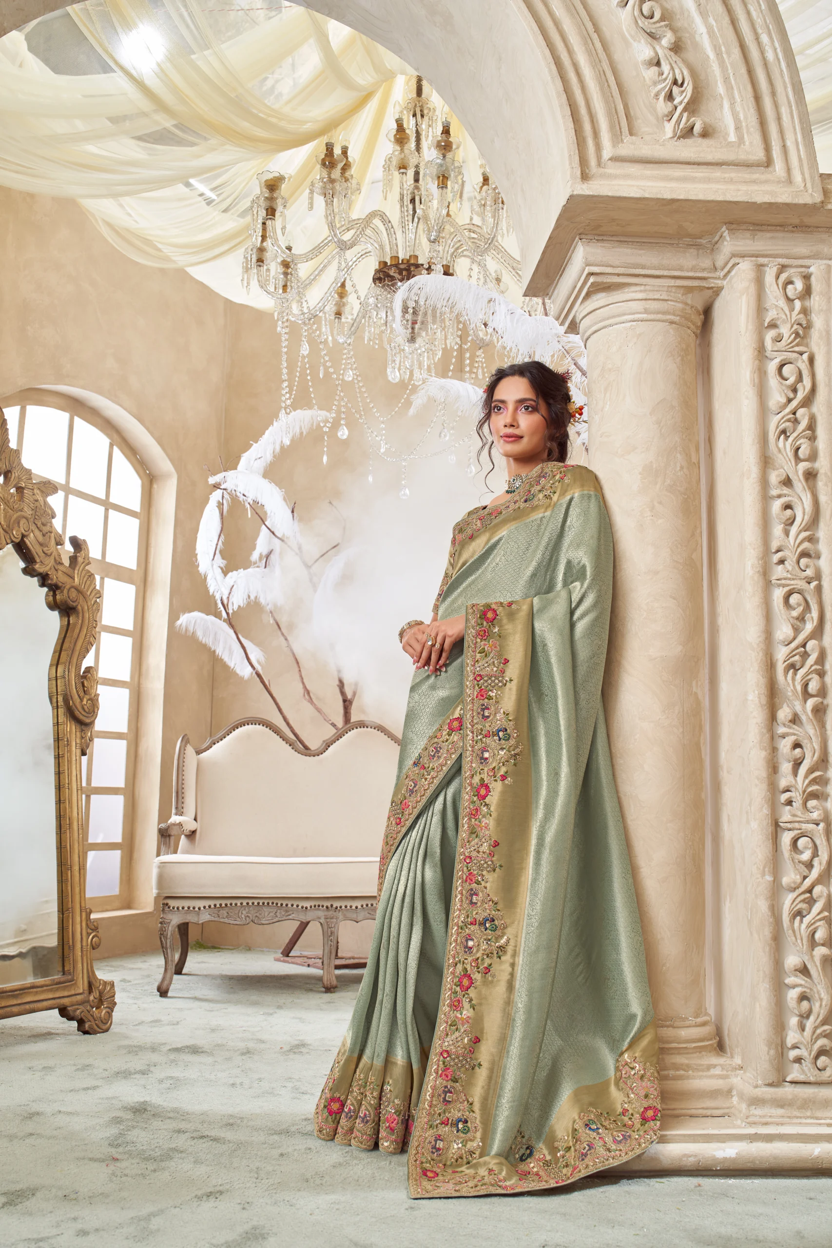 Model wearing a mint gold hand-embroidered designer saree with heavily embellished border and unstitched blouse.