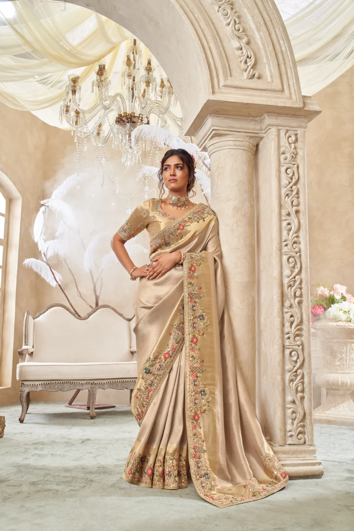 Model wearing a champagne gold designer saree with heavy hand-embroidered border and matching unstitched blouse.