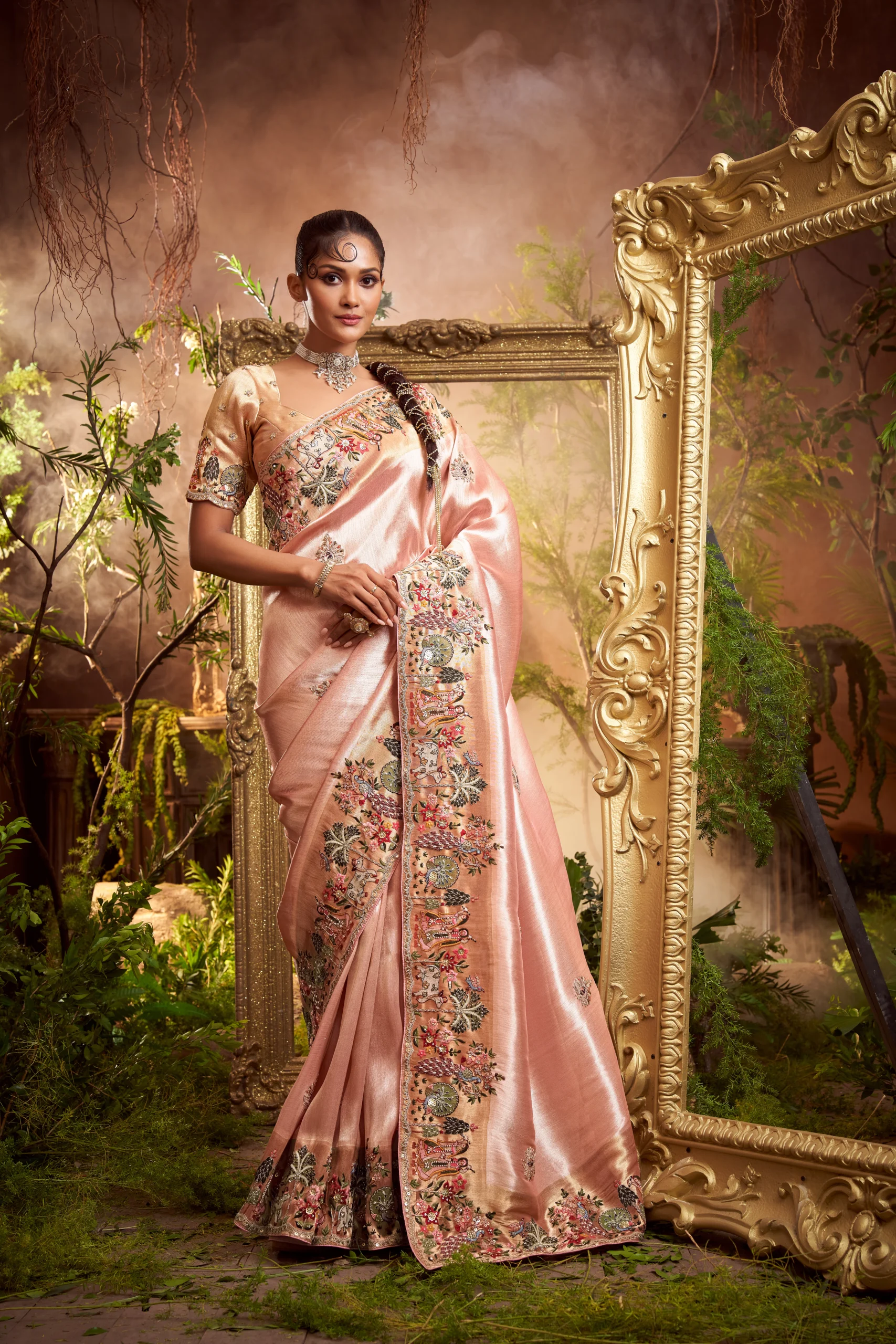 Model wearing a blush rose designer saree with heavy hand-embroidered border and matching embroidered unstitched blouse.