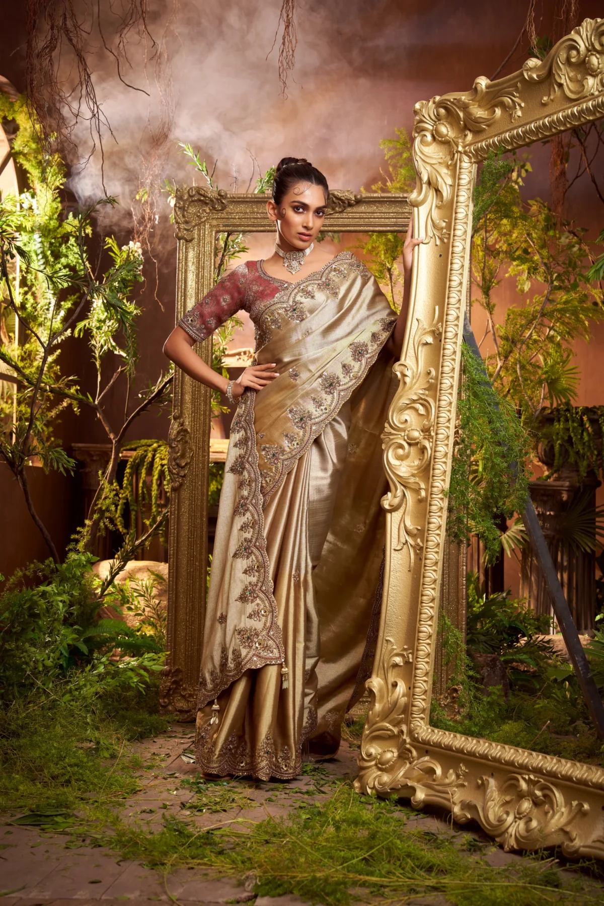 Model wearing a gold hand-embroidered designer saree with contrast embroidered blouse and scalloped border.