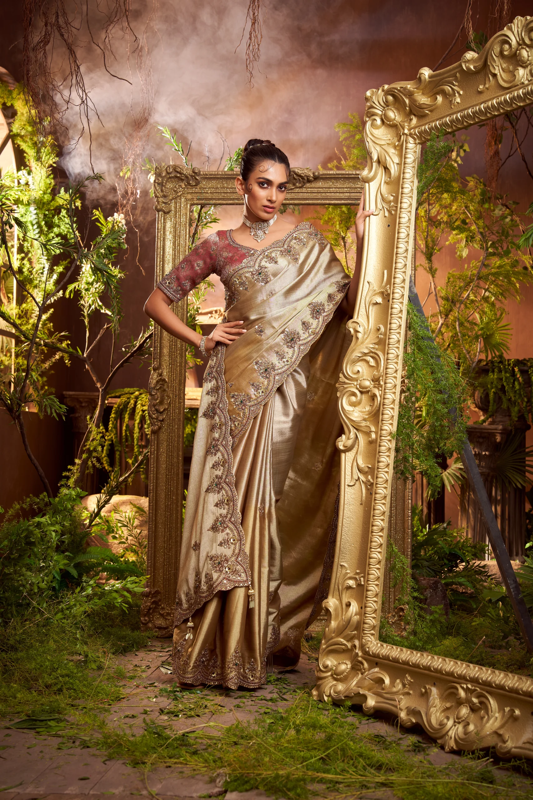 Model wearing a gold hand-embroidered designer saree with contrast embroidered blouse and scalloped border.
