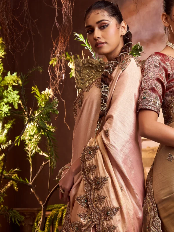 Model wearing a blush pink hand-embroidered designer silk saree with scalloped border and contrast blouse.