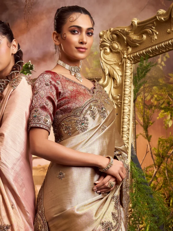 Model wearing a gold hand-embroidered designer saree with contrast embroidered blouse and scalloped border.