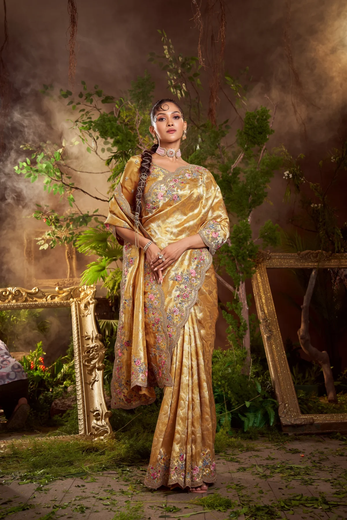 Model wearing antique gold hand-embroidered designer silk saree with floral motifs and embellished border.