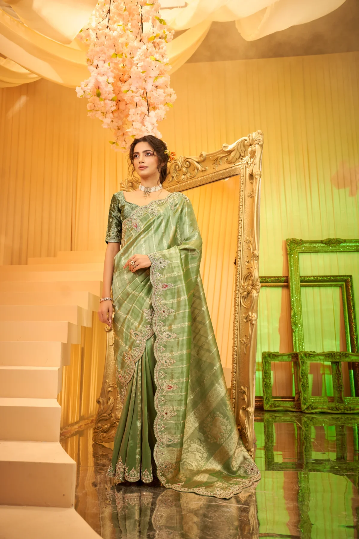 Model wearing an emerald green scallop-embroidered luxury silk saree with intricate stone and threadwork.