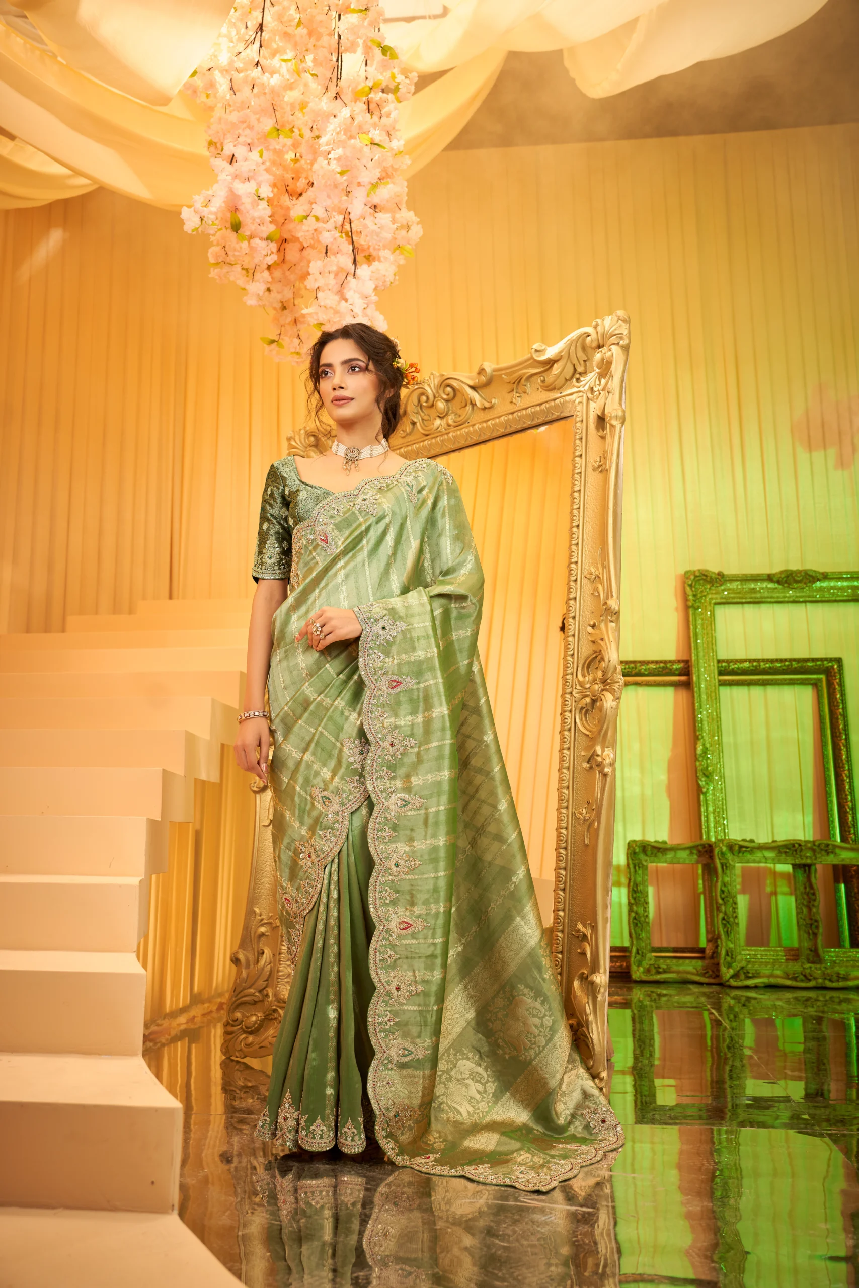 Model wearing an emerald green scallop-embroidered luxury silk saree with intricate stone and threadwork.