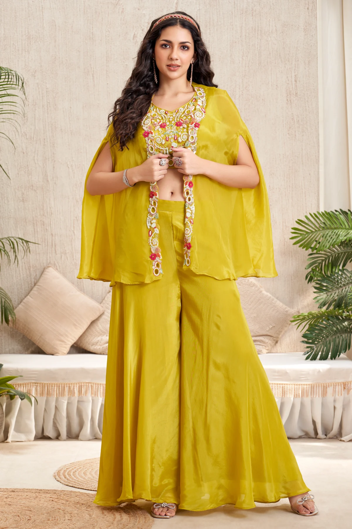Yellow embroidered blouse with cape overlay and wide flare bottoms Indo-Western festive outfit for women.