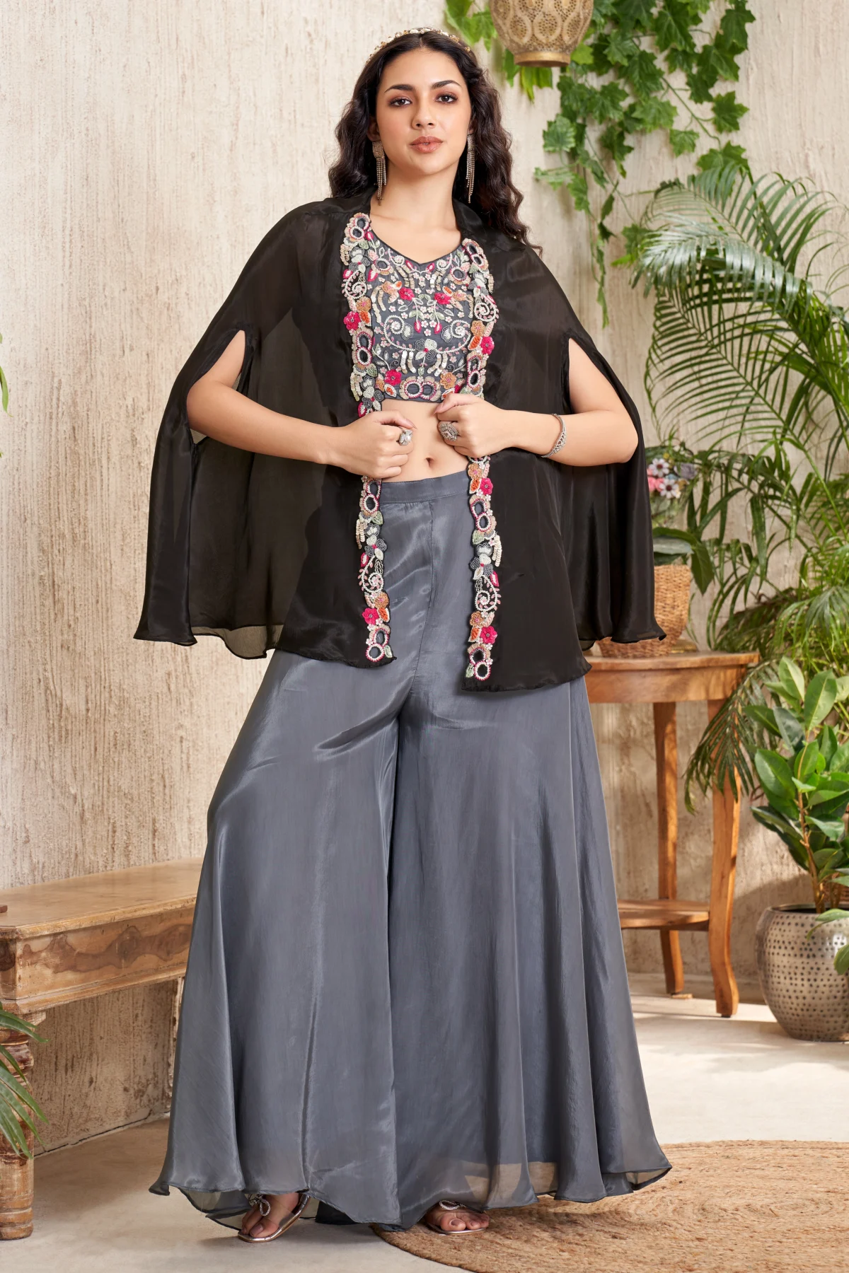 Black embroidered blouse with sheer cape overlay and grey wide flare bottoms Indo Western outfit for women.