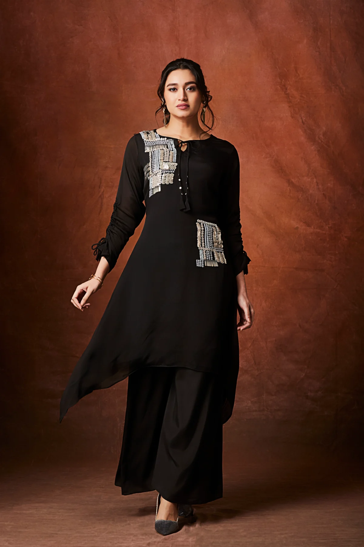 Black asymmetrical palazzo suit with metallic patch embellishment and wide leg pants for festive wear.