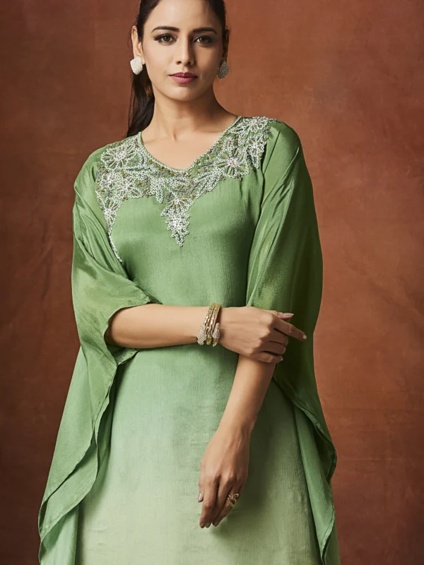 Emerald green Indo Western kurta set with embellished neckline and straight slit pants for festive wear.