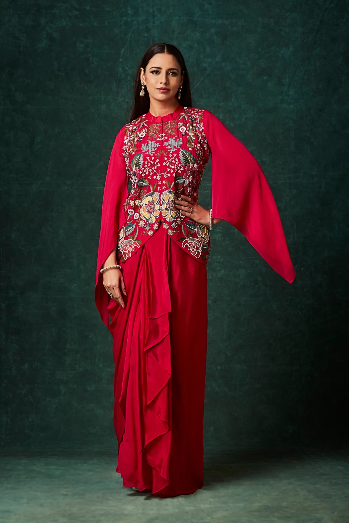 Crimson red Indo Western drape set with floral embroidered bodice and cape sleeves for reception and cocktail wear.