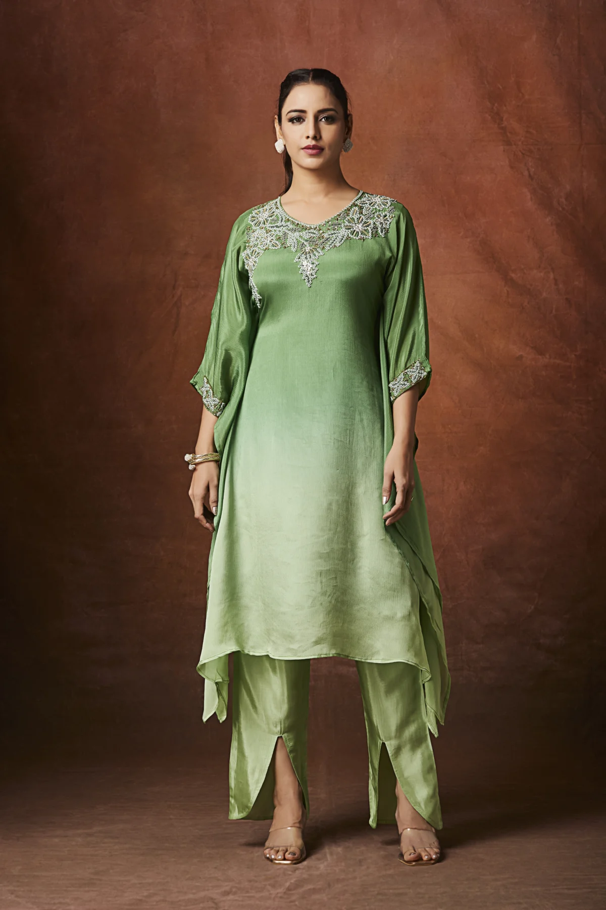 Emerald green Indo Western kurta set with embellished neckline and straight slit pants for festive wear.