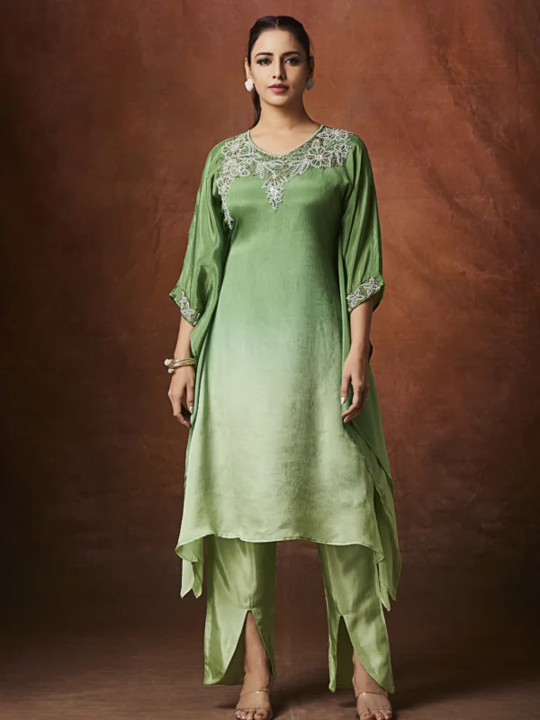 Emerald green Indo Western kurta set with embellished neckline and straight slit pants for festive wear.