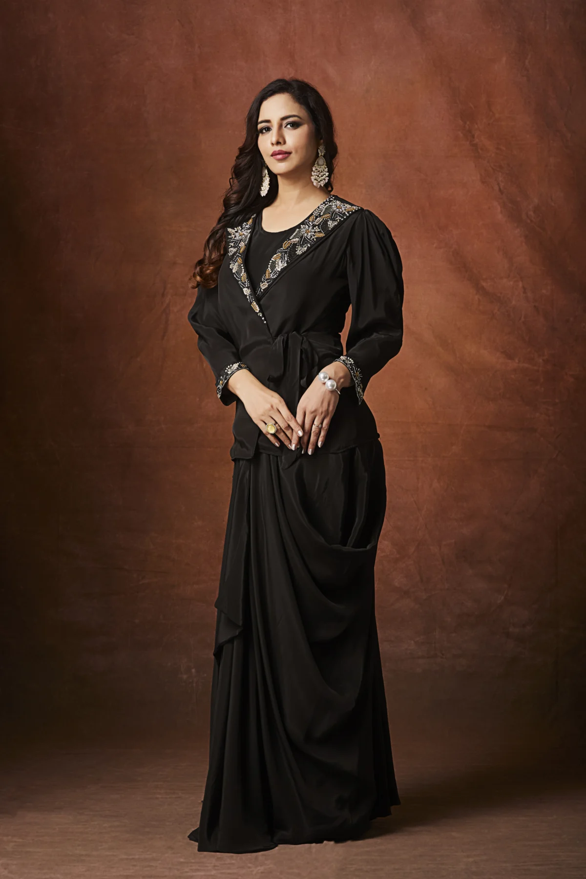 Black embellished Indo Western draped outfit with wrap blouse and long flowing skirt for evening wear.